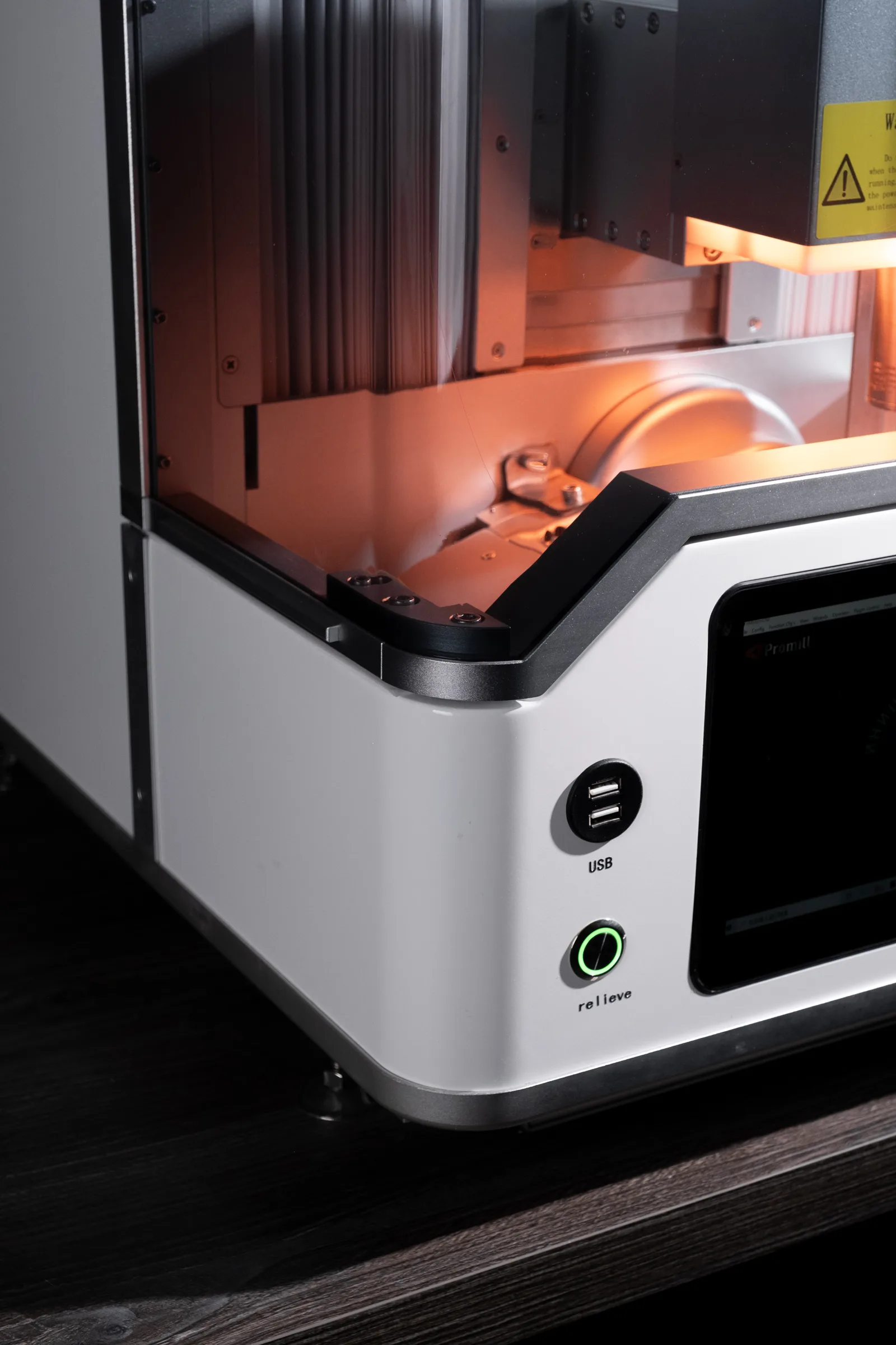 3D-принтер с открытой дверцей и нагретой оранжевой платформой печати, белый корпус с кнопкой питания и USB-портами, на рабочем столе